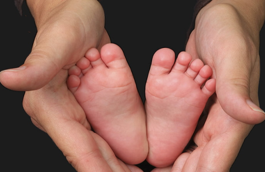 mom holding baby feet in her hands